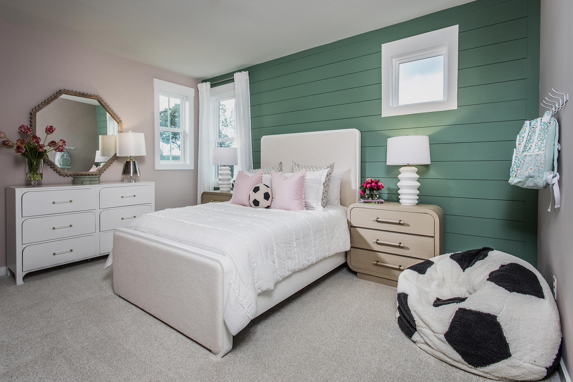 secondary bedroom with full bed and shiplap accent wall
