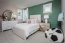 secondary bedroom with full bed and shiplap accent wall 