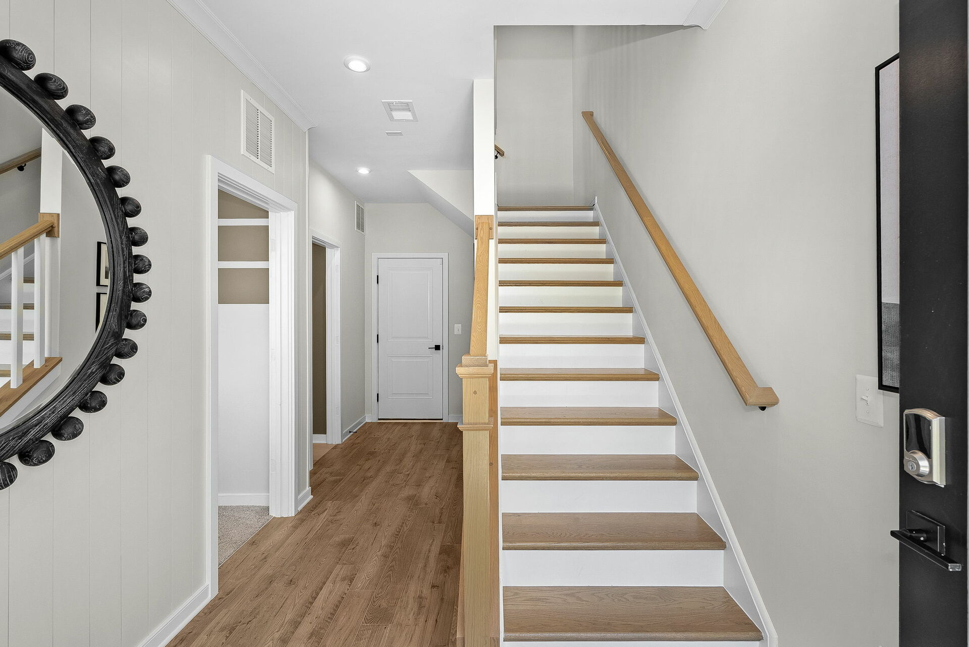 foyer with hardwood floors, entrance to bedrooms and stairway