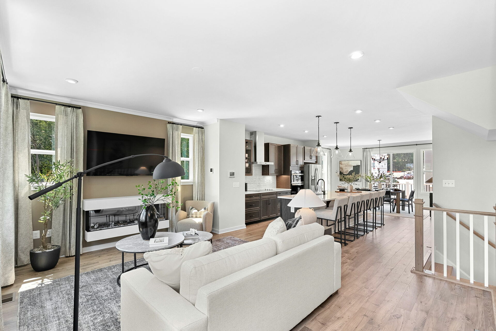 sofa with hardwood floors and carpet, fireplace, sofa, and tvs