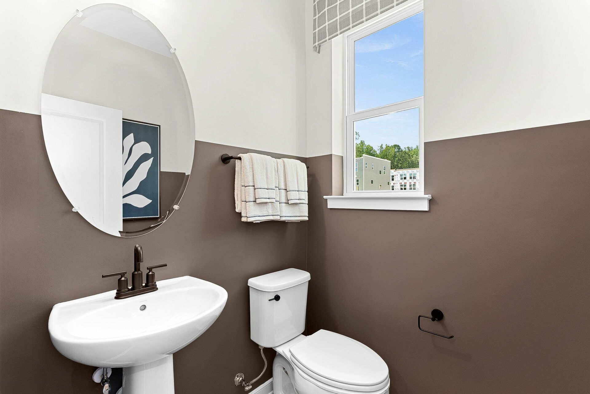 bathroom with toilet and sink next to window