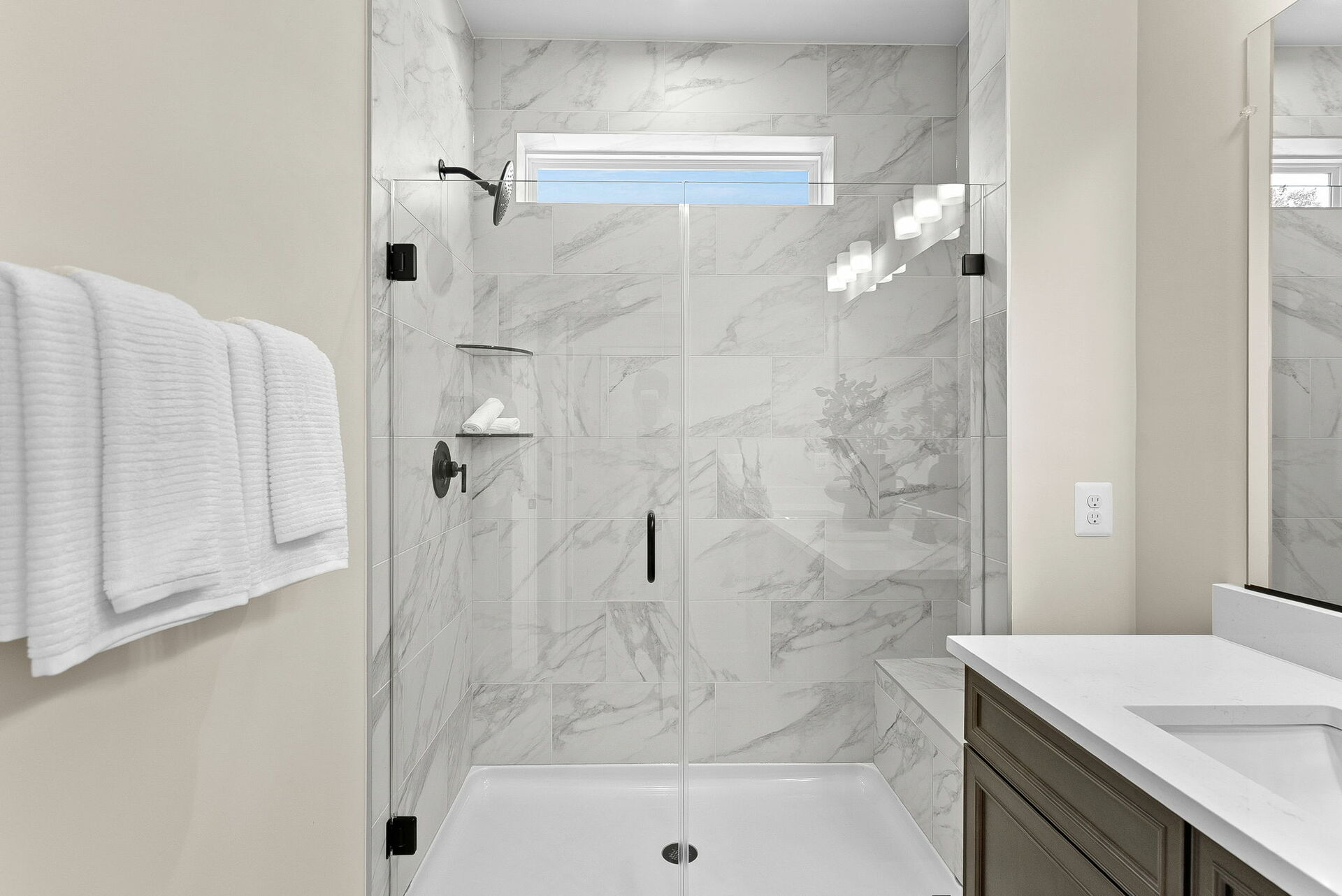 bathroom with walk in shower with tile and glass doors