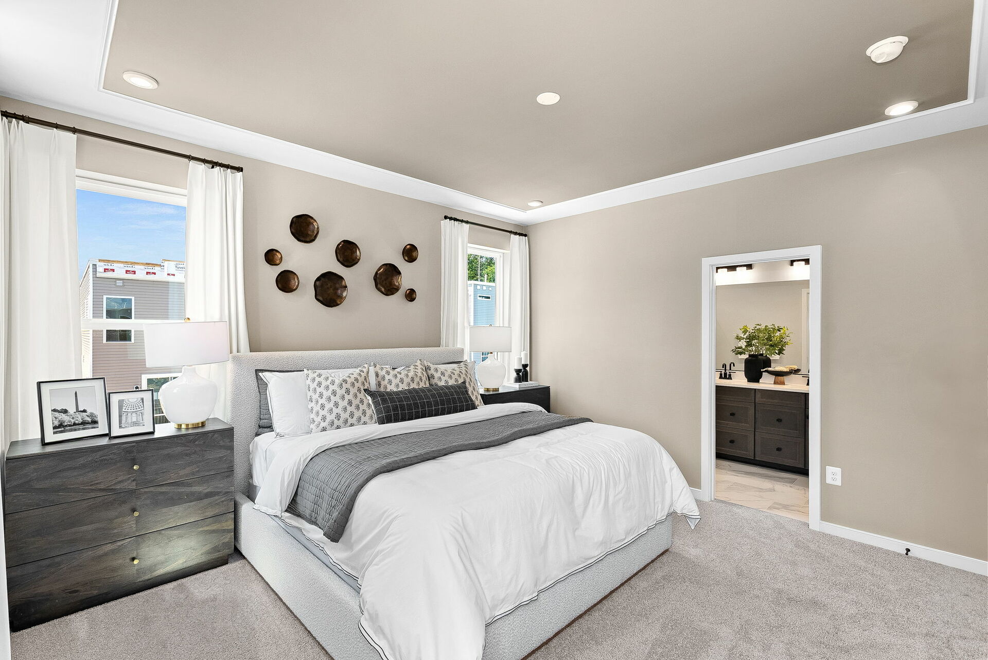 bedroom with carpet, large bed and dresser beside bed