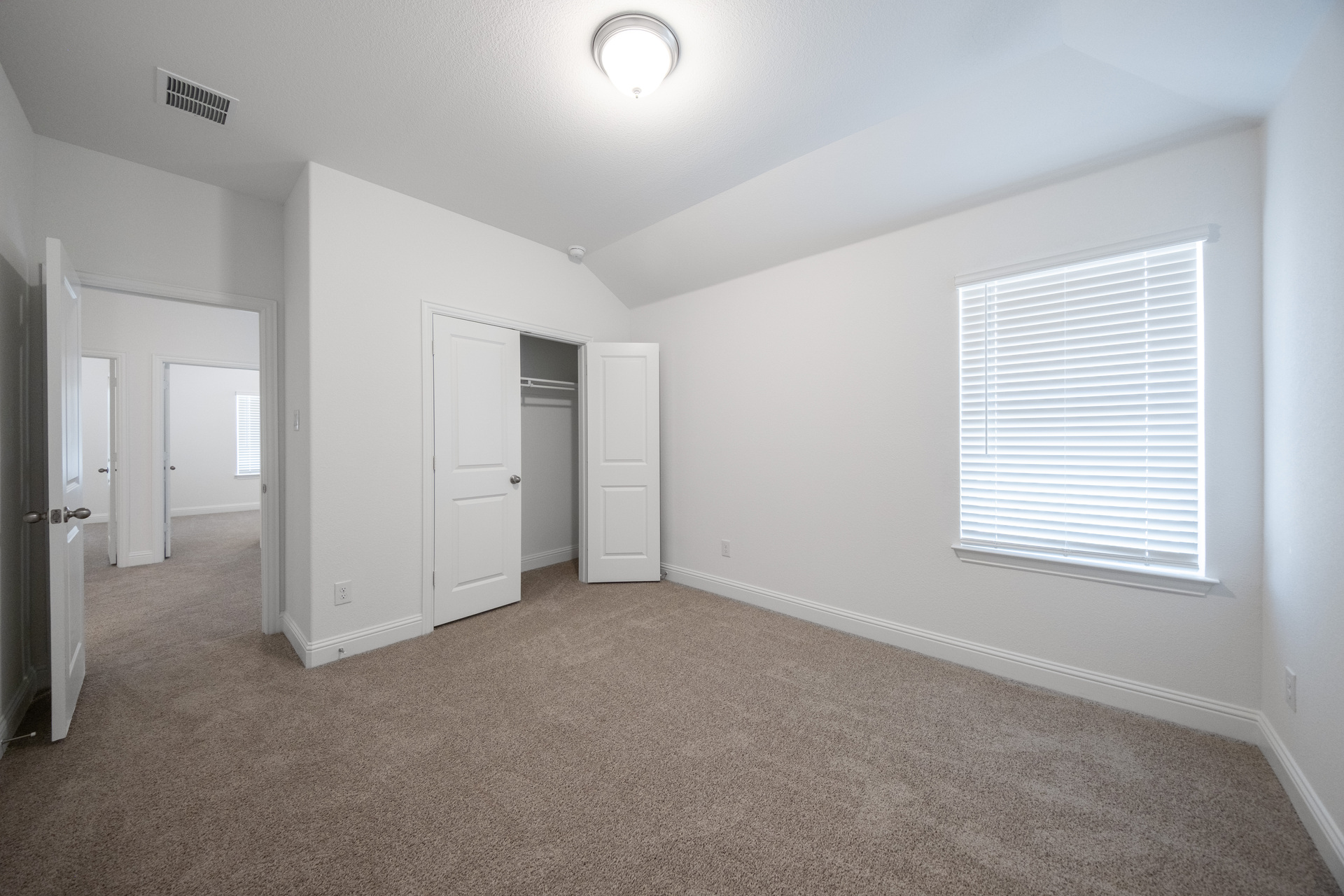 guest bedroom with carpet and window