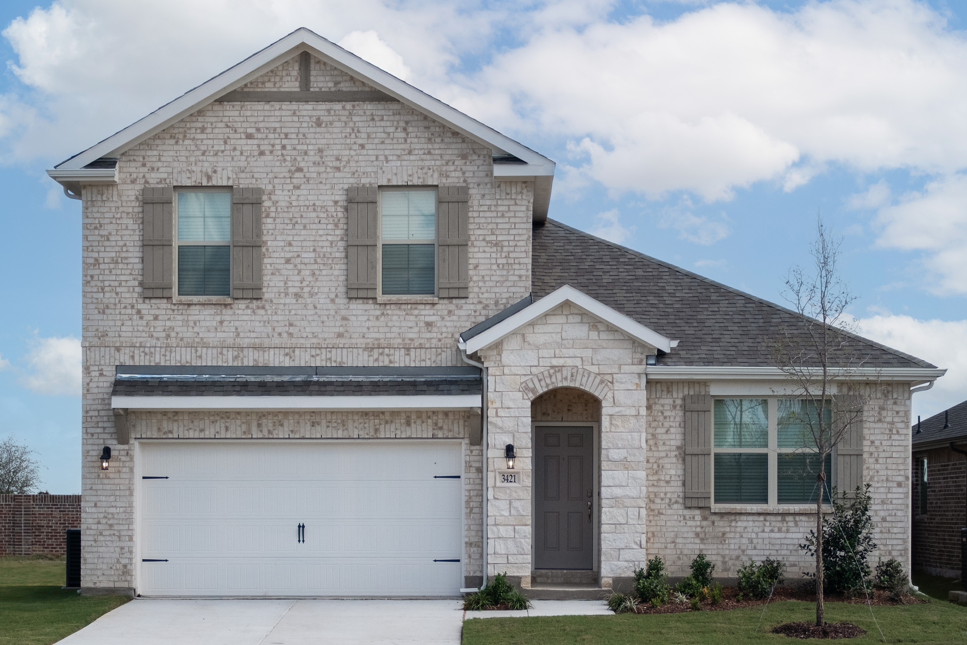 exterior of home with tan brick and white stone
