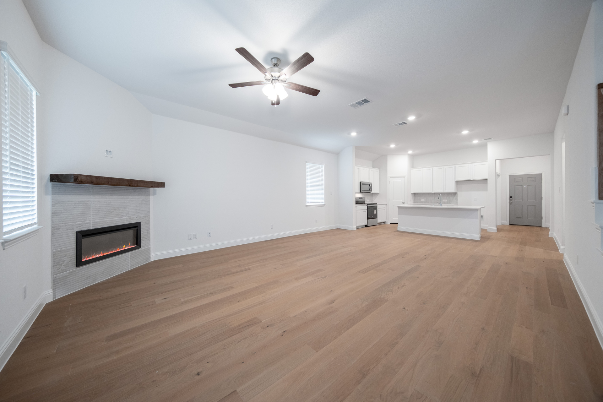 spacious great room with electric fireplace and hardwood flooring