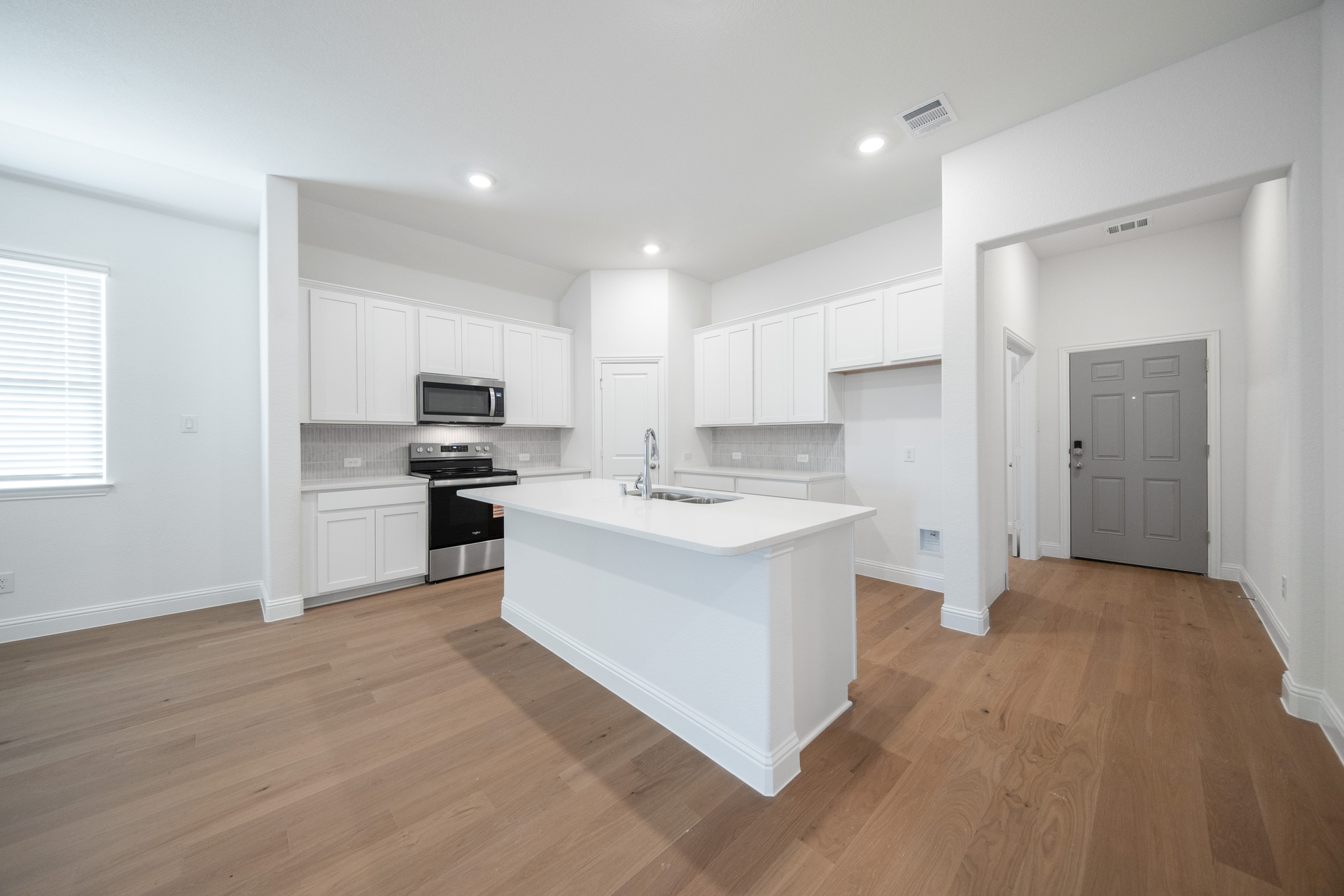 open kitchen with white cabinets and hardwood flooring