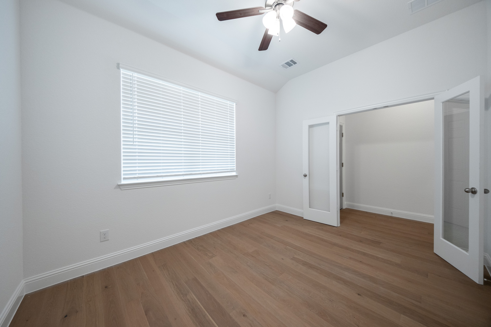 private study with hardwood flooring and window