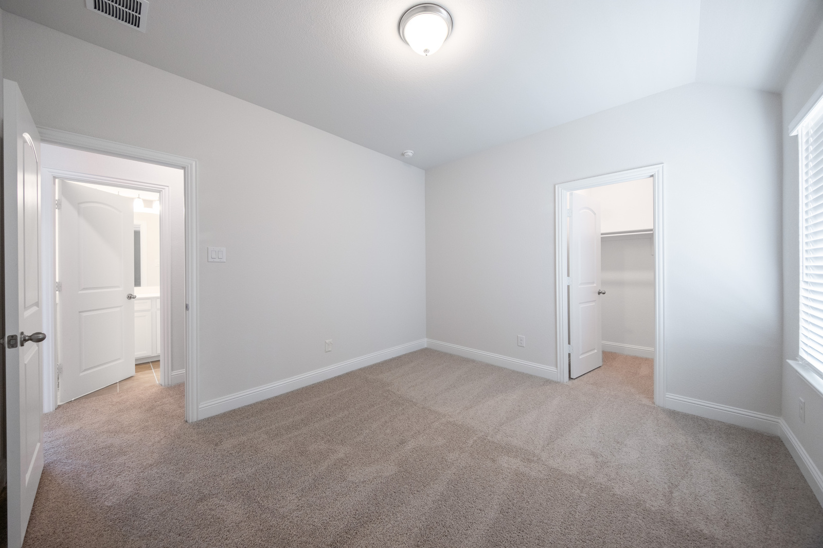 guest bedroom with carpet and walk-in closet