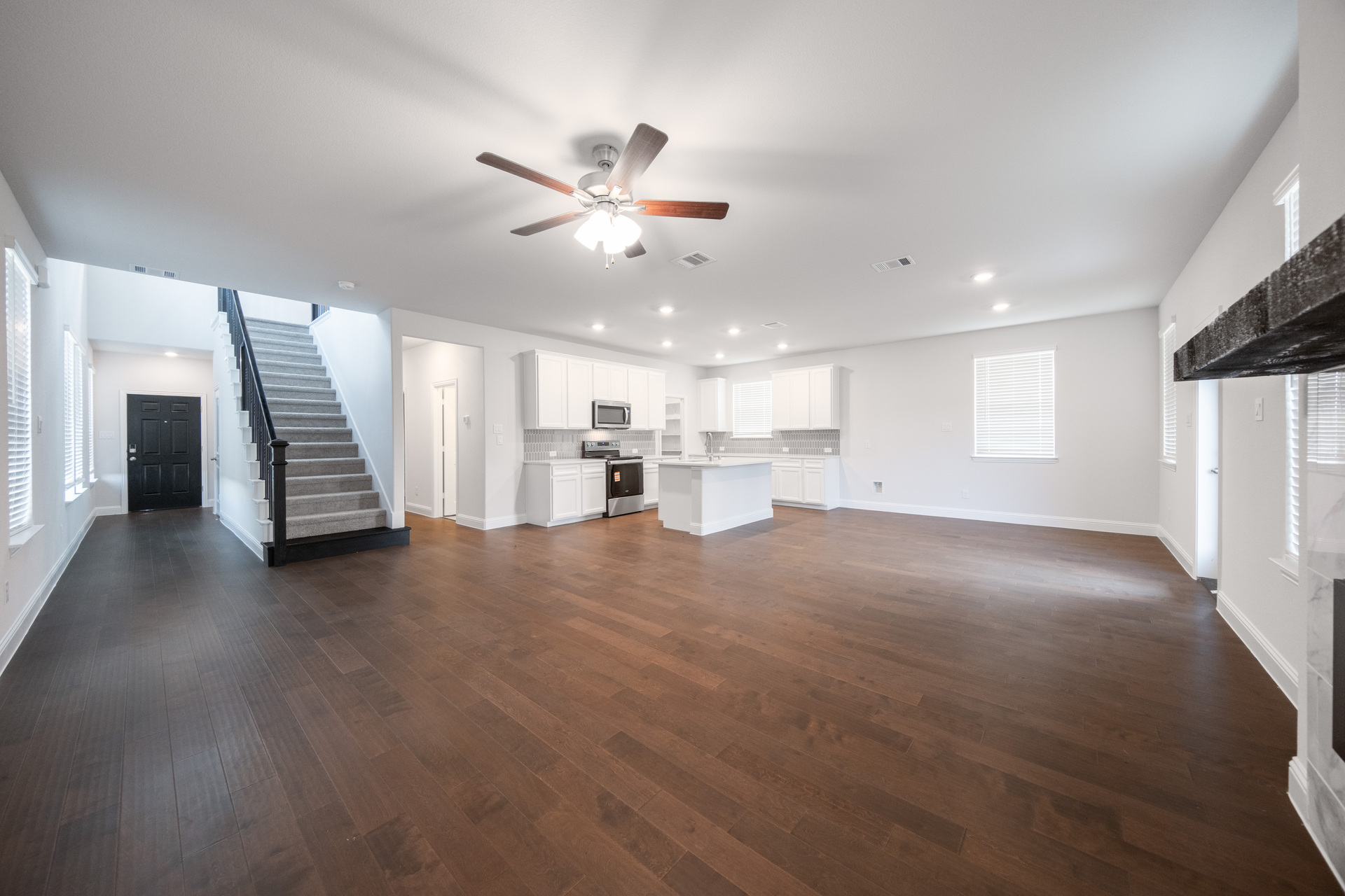 open great room with hardwood flooring and windows