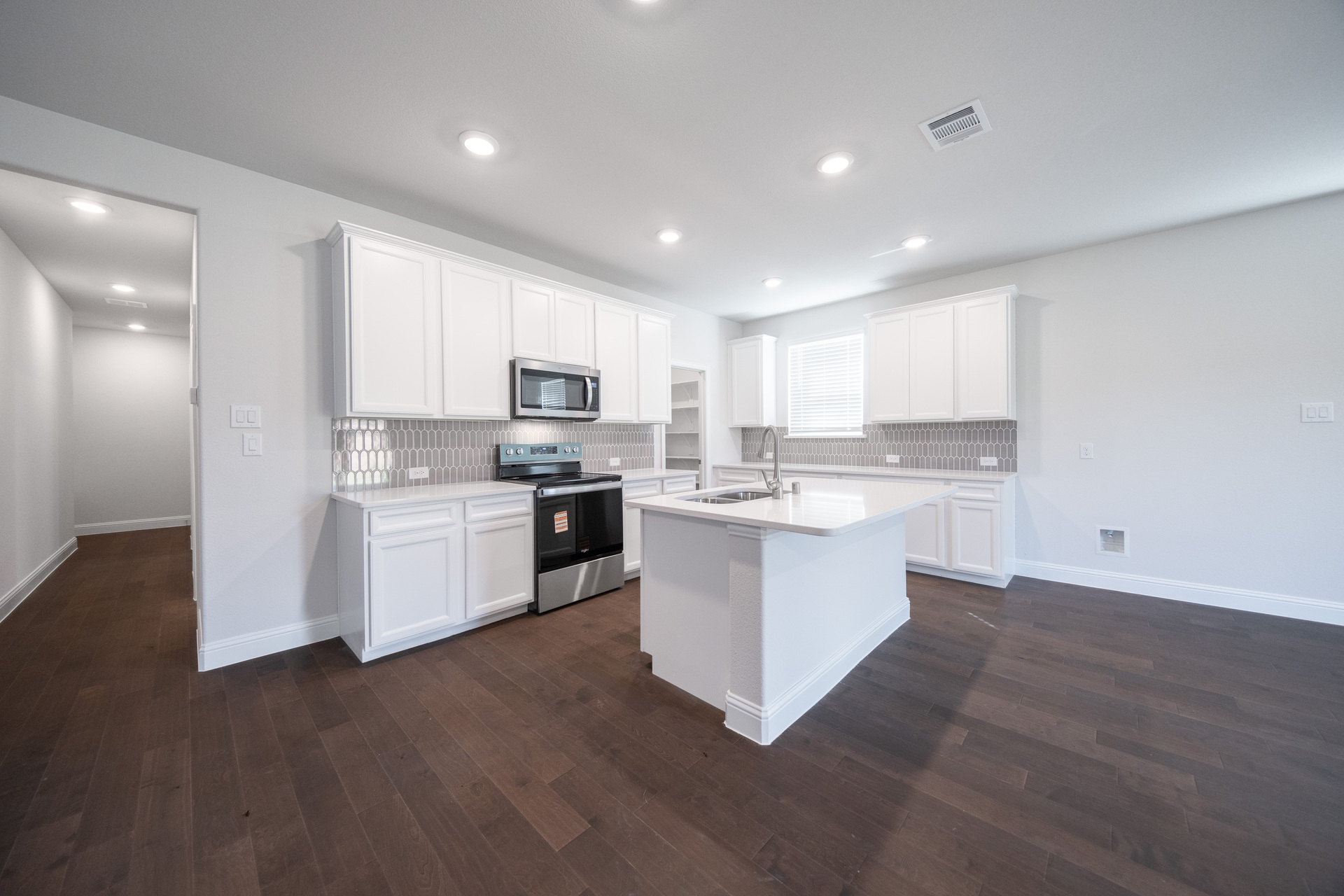 open kitchen with white cabinets and hardwood flooring