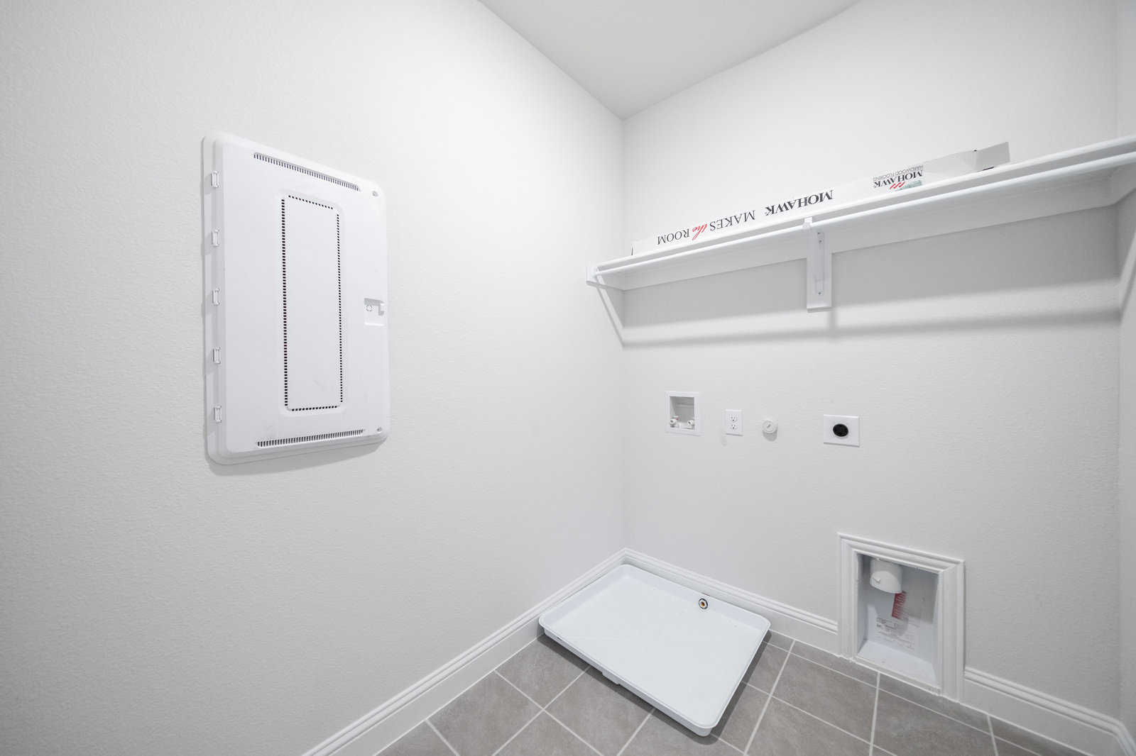 laundry room with tile flooring and storage shelf