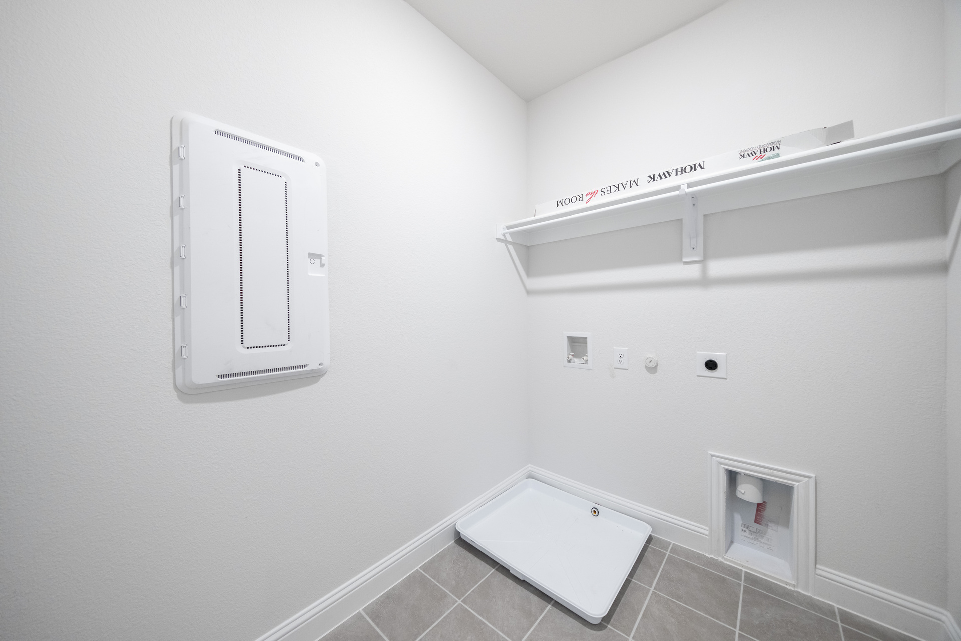 laundry room with tile flooring and storage shelf