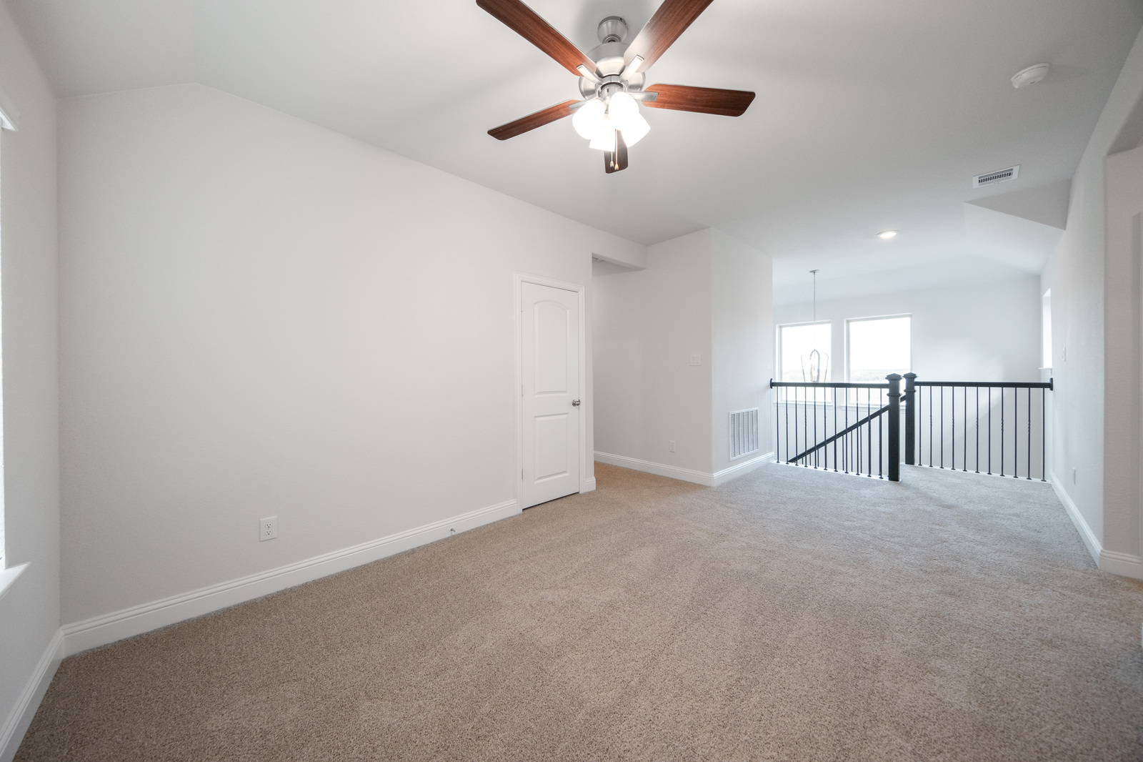 spacious loft with carpet and ceiling fan