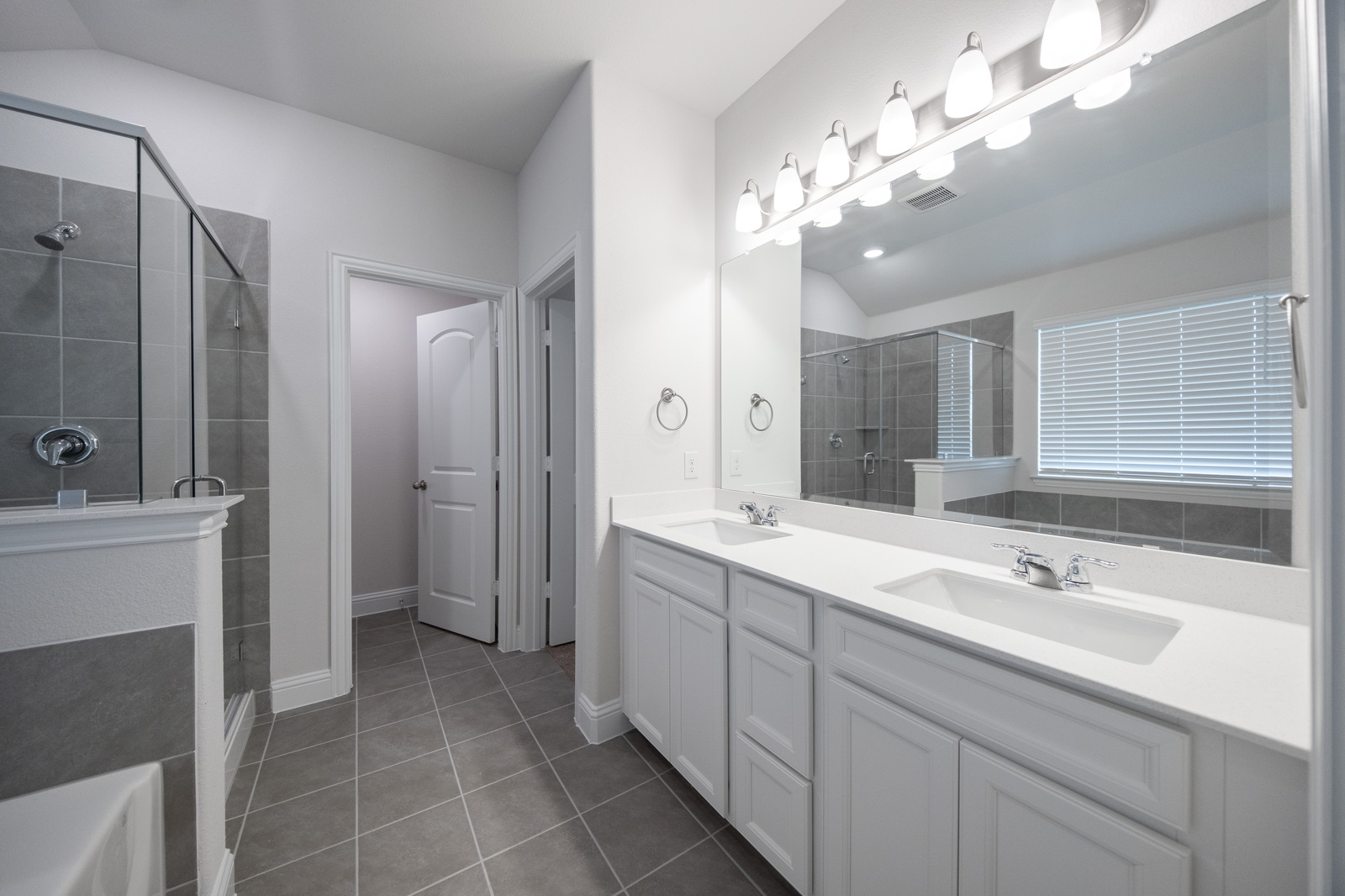 primary bathroom with tile flooring and double sinks