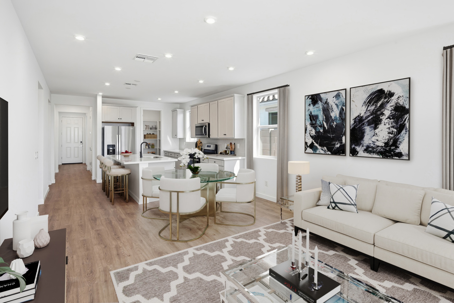 open-concept space with a large white couch, glass coffee table, and glass dining table