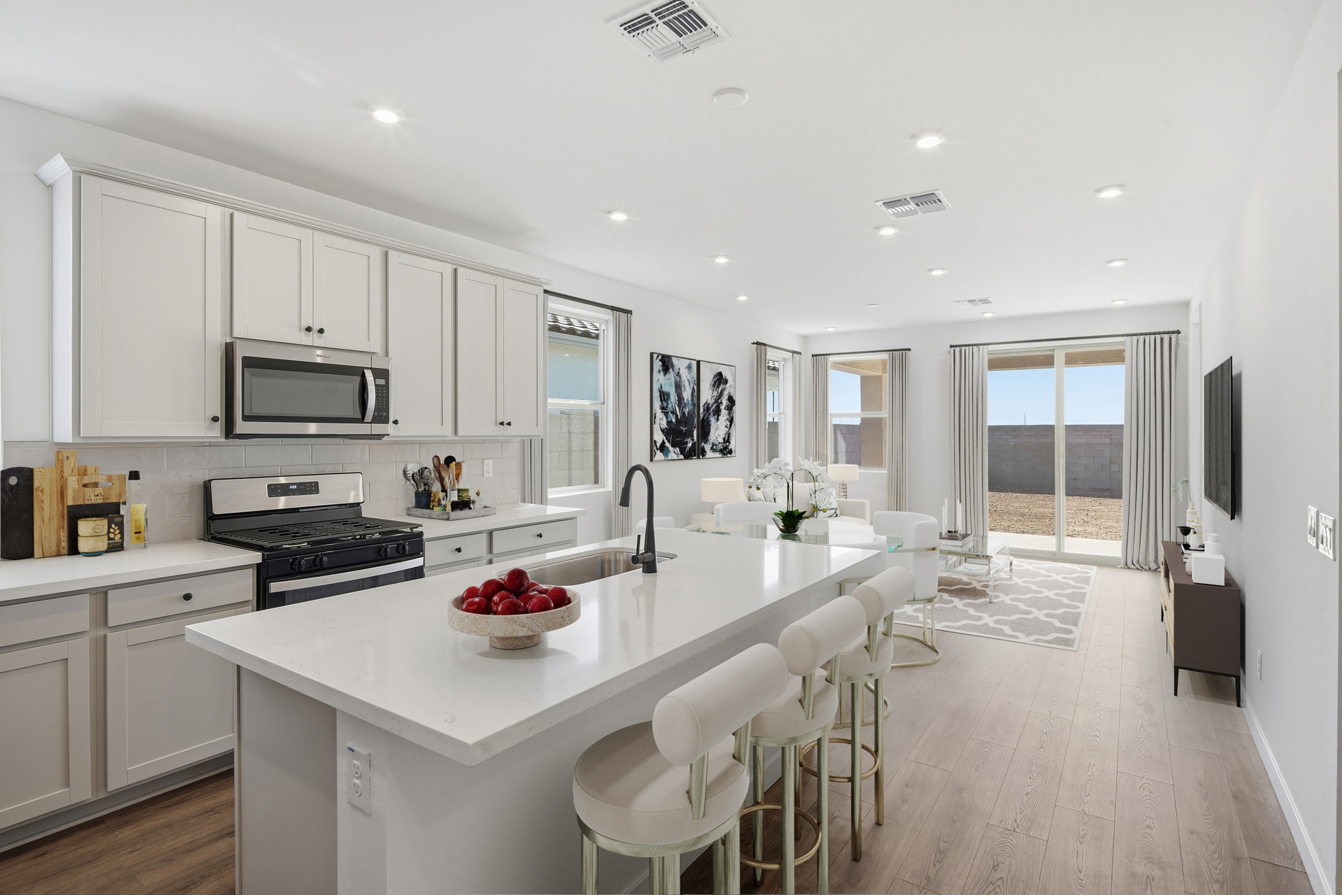 kitchen with white barstools, quartz countertops, and a black kitchen faucet