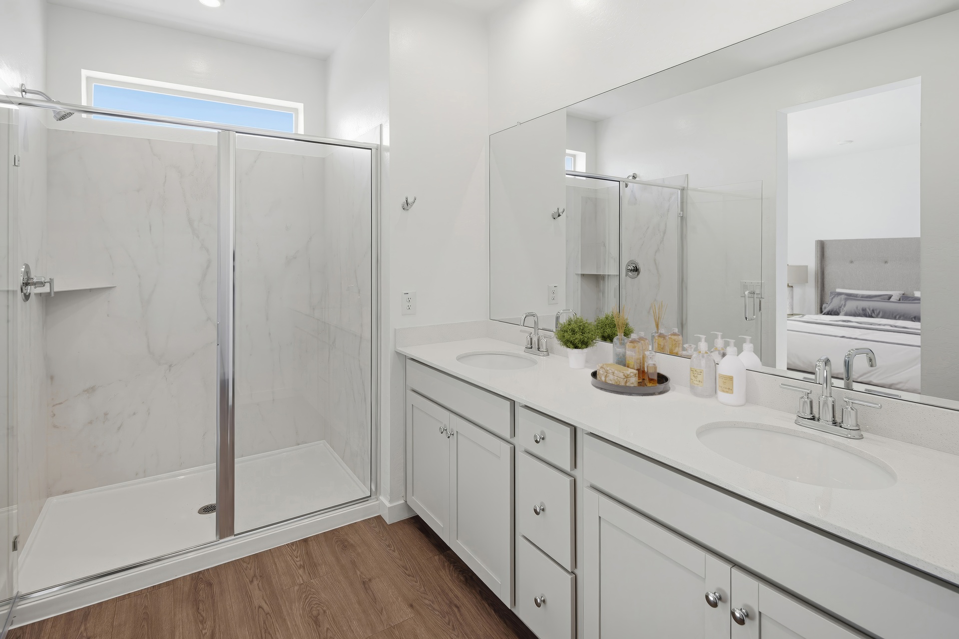 spacious bathroom with large walk-in shower, grey cabinets, and chrome faucets
