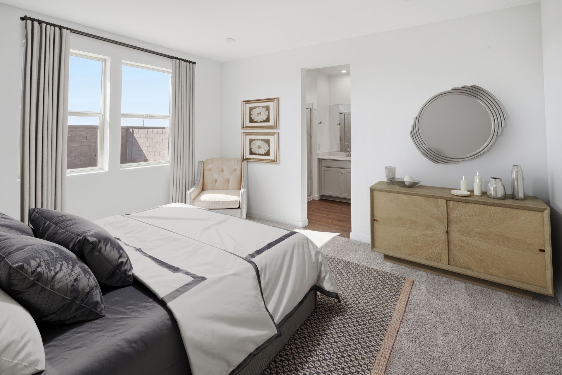 spacious bedroom with a large bed with silk black bed sheets, a wooden dresser, and plenty of natural light