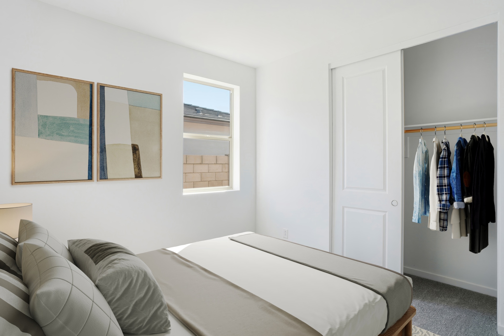 bedroom with a large bed, artwork on the wall, and a closet with a sliding door