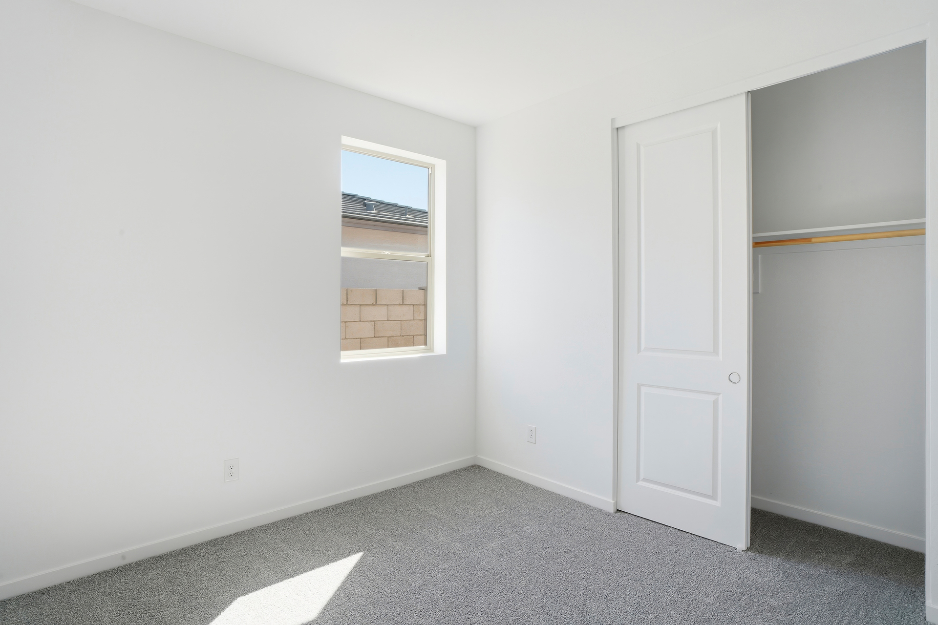 bedroom with light grey carpet and closet with sliding door