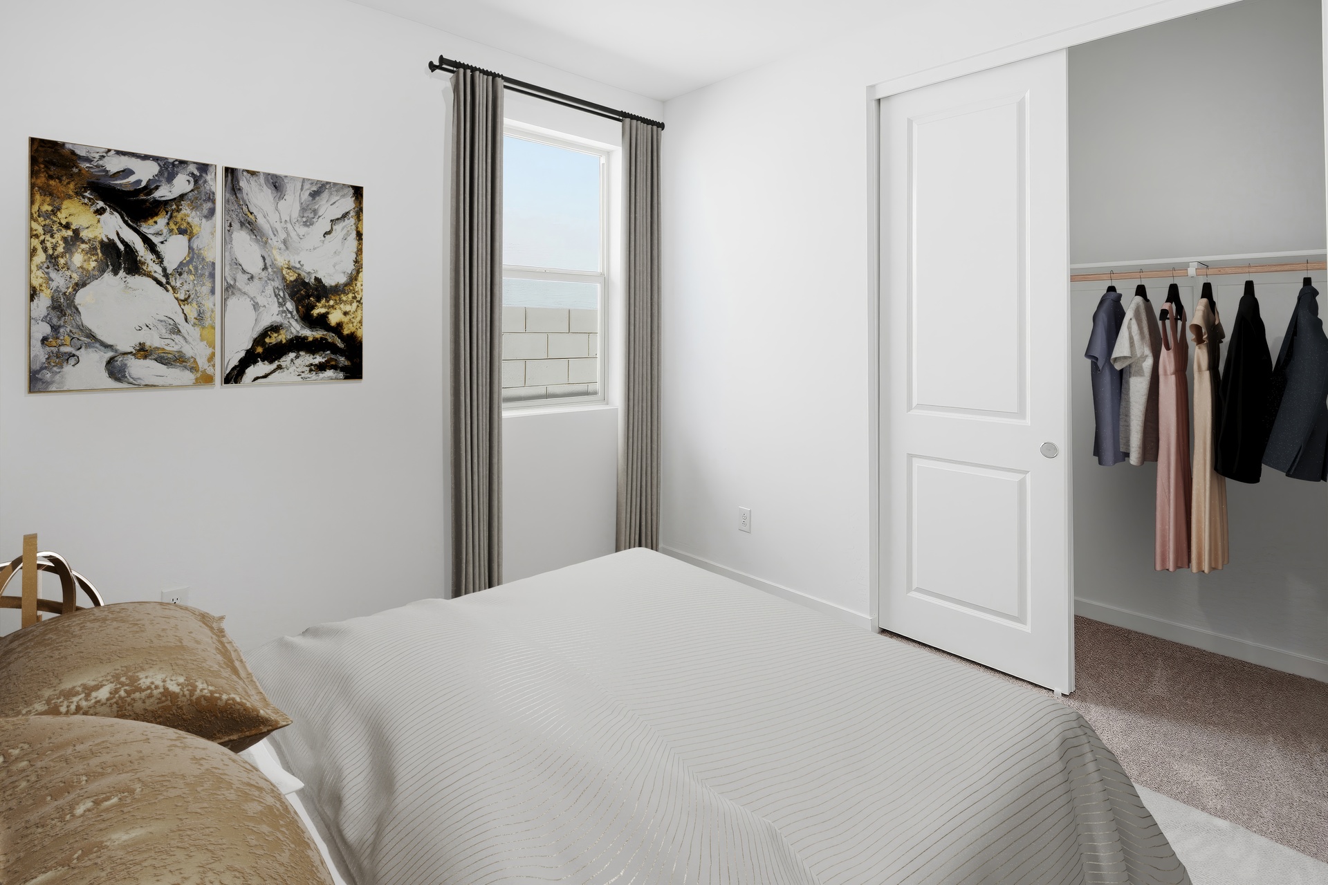 bedroom with a large bed, a grey rug, and gold-colored pillows and art
