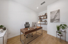at home office with walnut desk, walnut bookshelf, and black office chair
