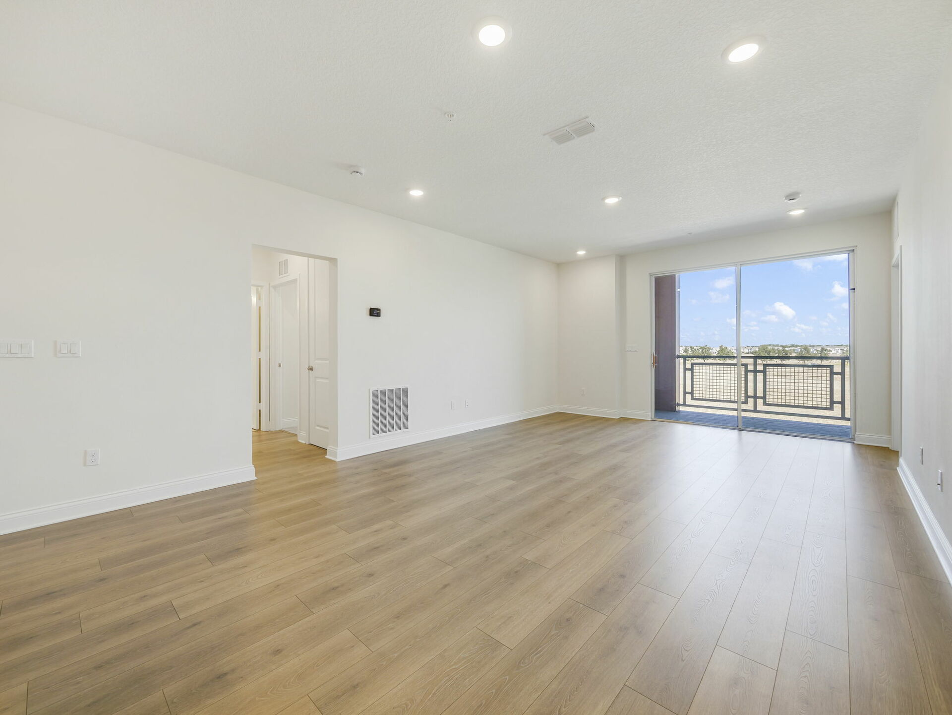 great room with access to the patio and view of the kitchen