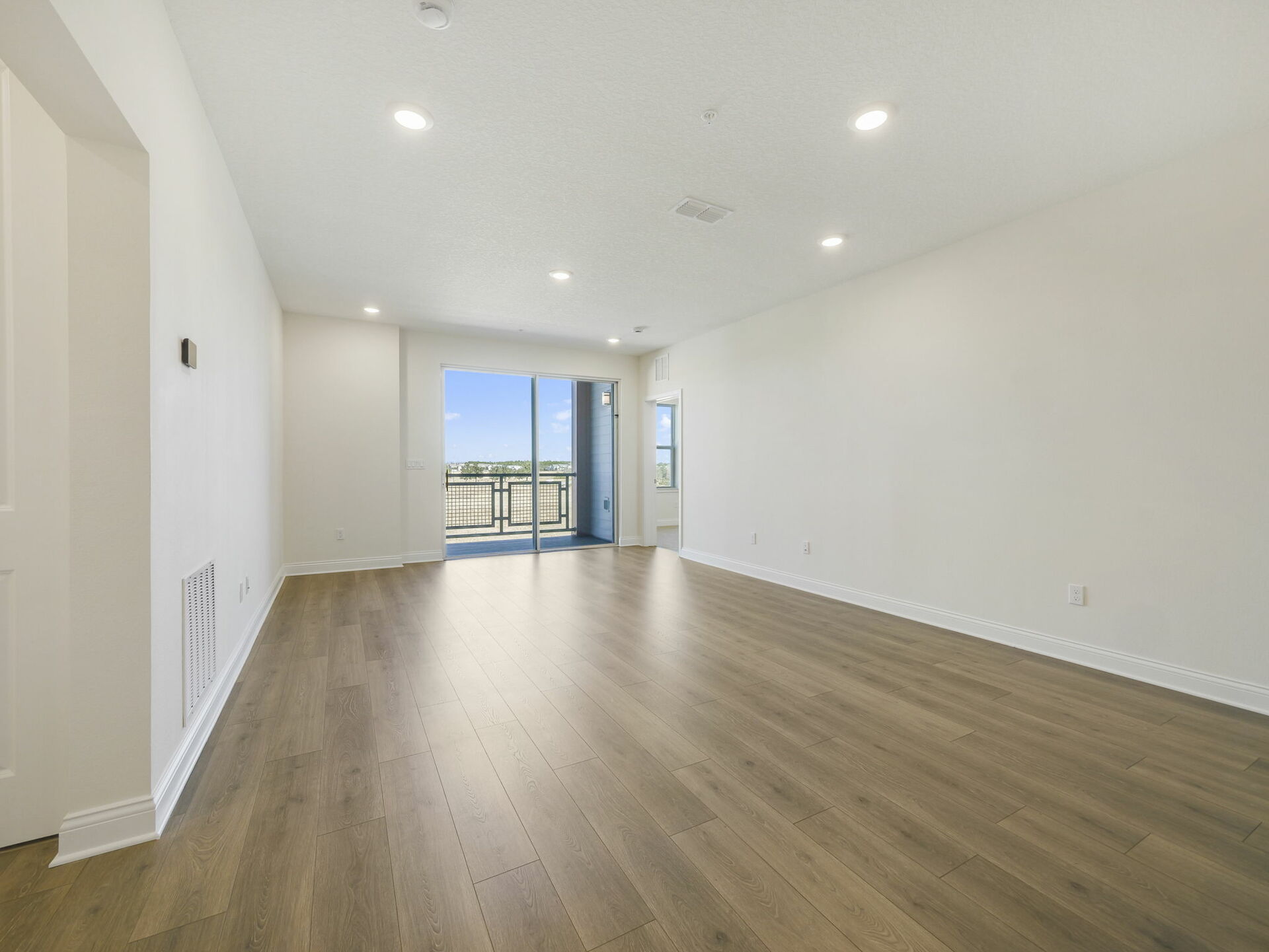 great room with access to the patio and view of the kitchen