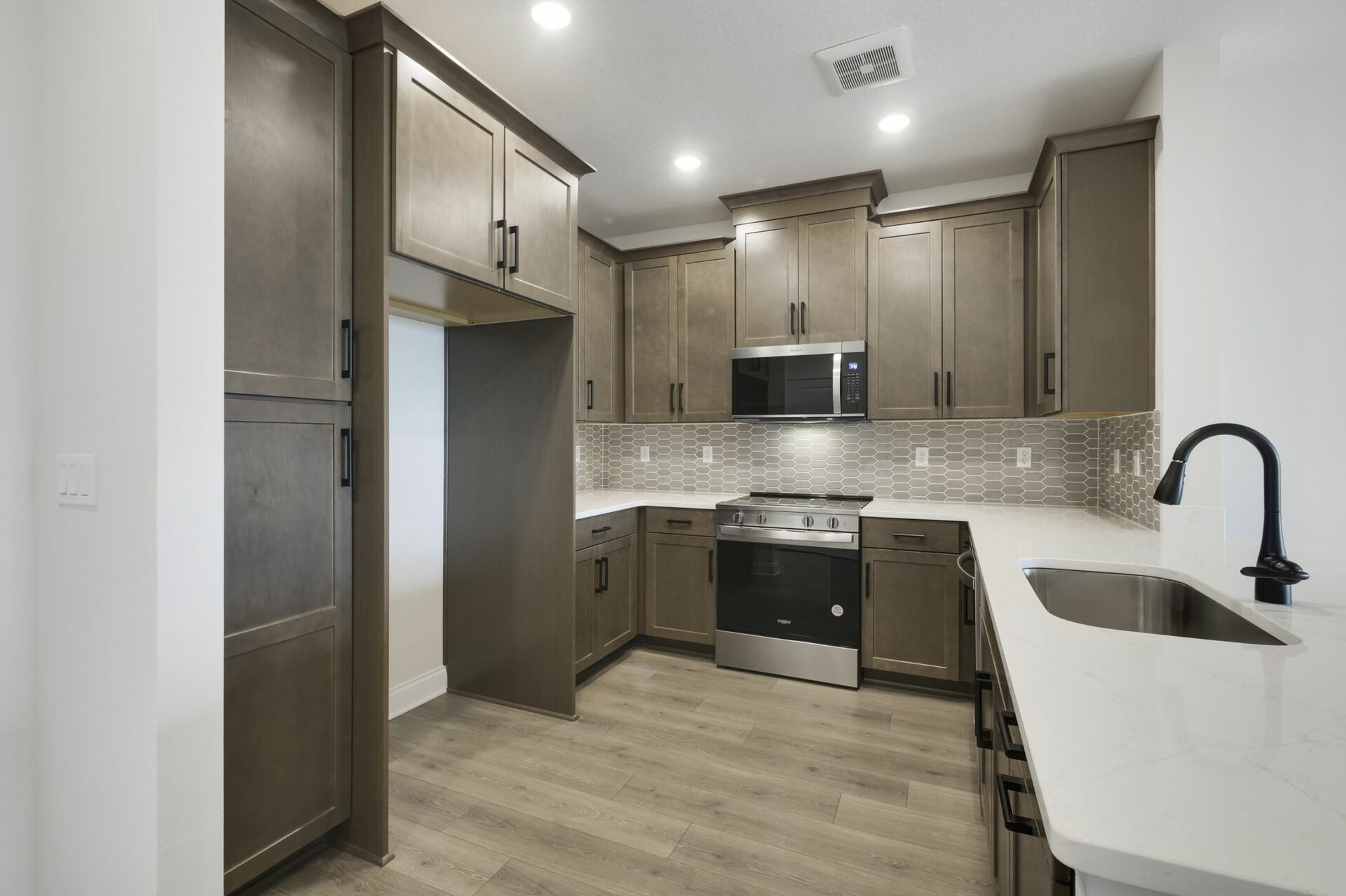 stainless steel appliances, natural wood cabinetry and deep kitchen sink 