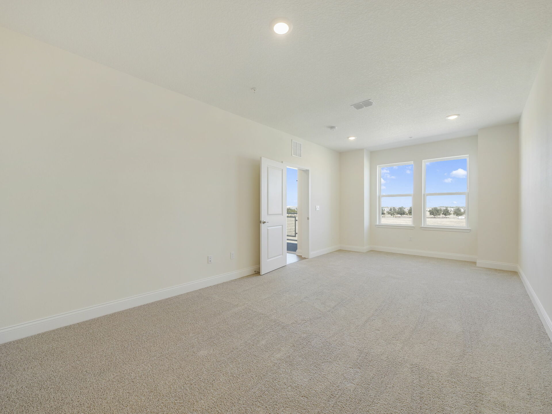 carpet throughout with view of sitting room and access to primary bathroom