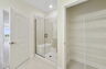 dual sink vanity with large mirror, water closet, shower and linen closet