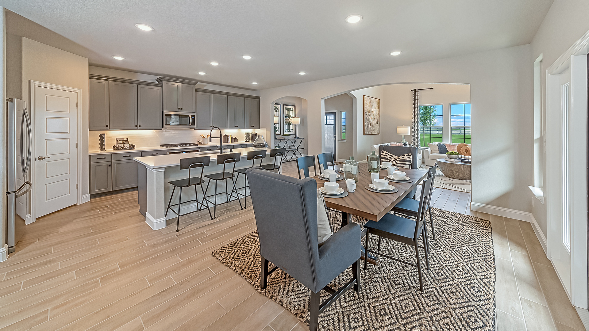 kitchen with gray cabinets, large island, and view of the dining room
