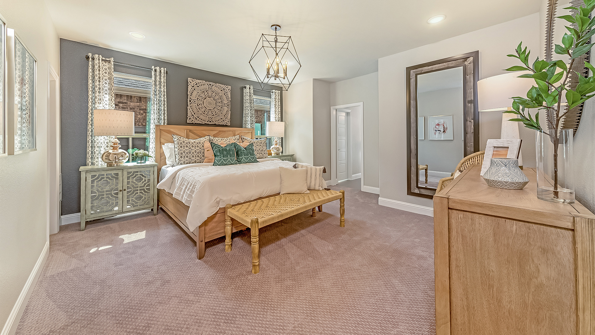 primary bedroom with carpet flooring, large bed, nightstands, a dresser, and large mirror