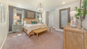 primary bedroom with carpet flooring, large bed, nightstands, a dresser, and large mirror
