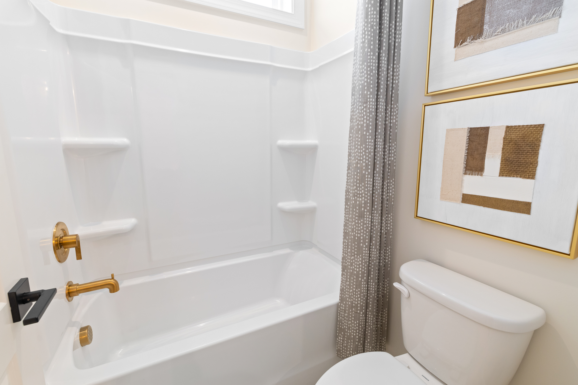 secondary bathroom with bathtub and gold hardware