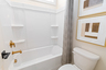 secondary bathroom with bathtub and gold hardware