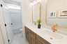 secondary bathroom with bathtub and gold hardware