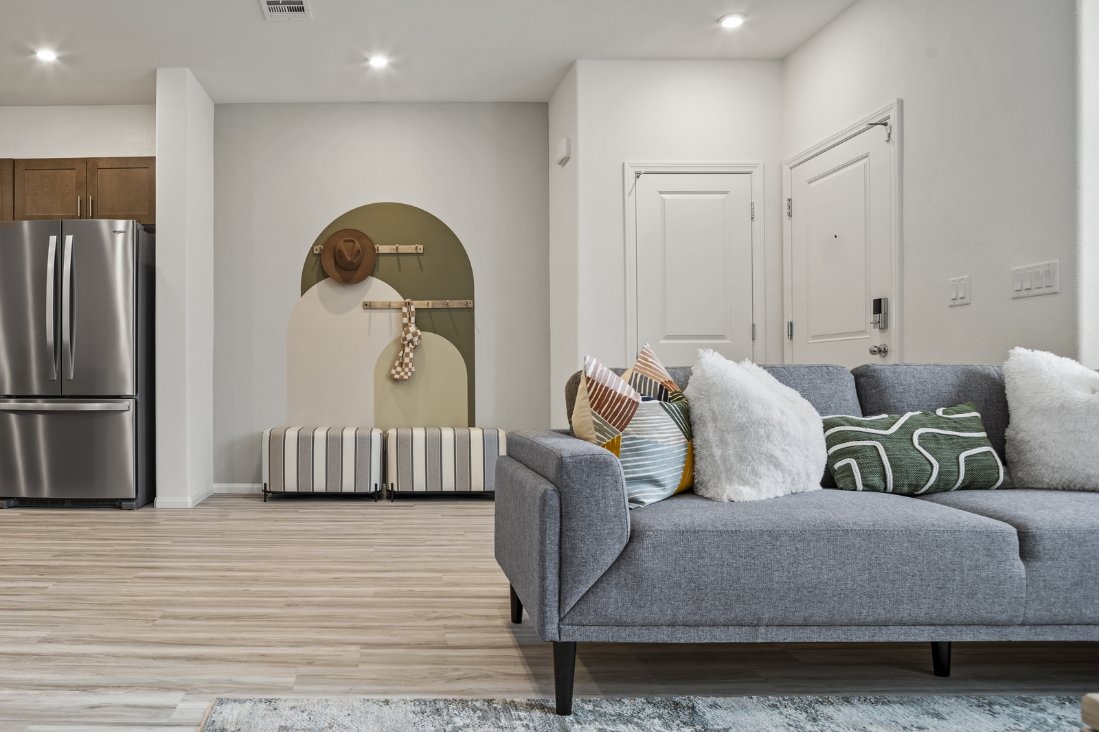 great room with couch, fridge, and front door