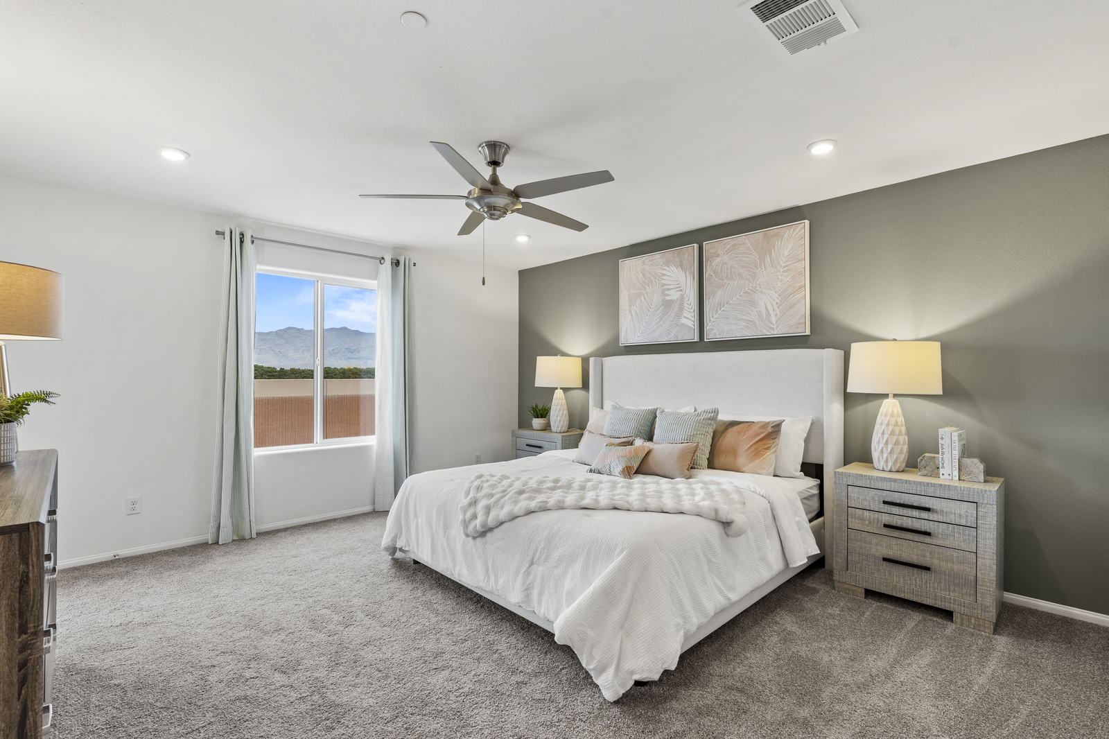 primary bedroom with large bed and accent wall