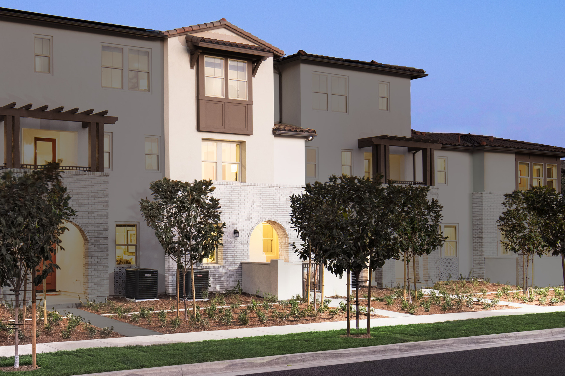 exterior of three-story townhome with large windows and neutral paint