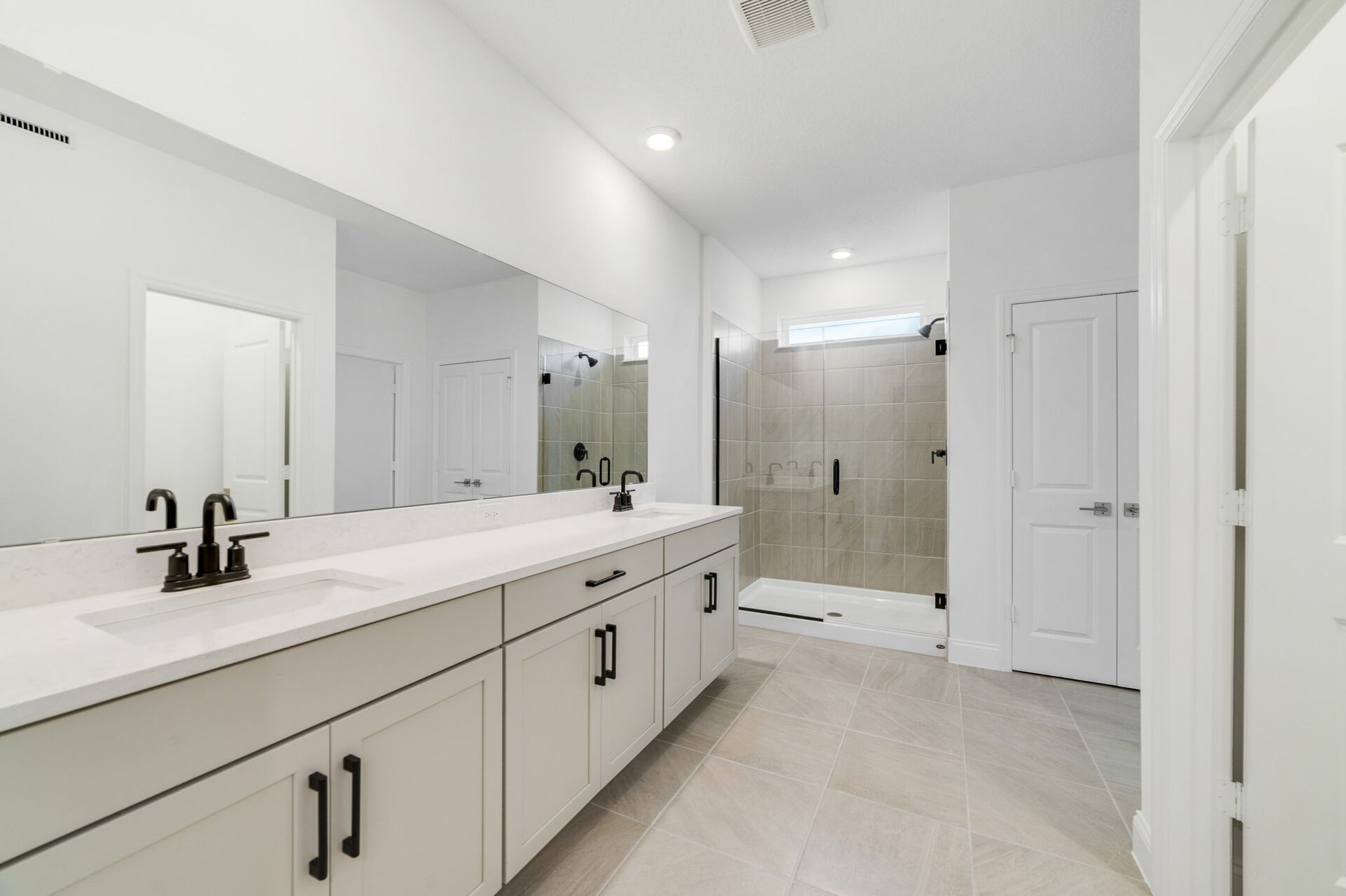 dual sink vanity with water closet and shower