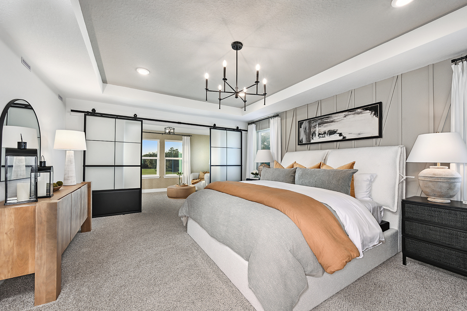 primary bedroom with tray ceiling and sitting room