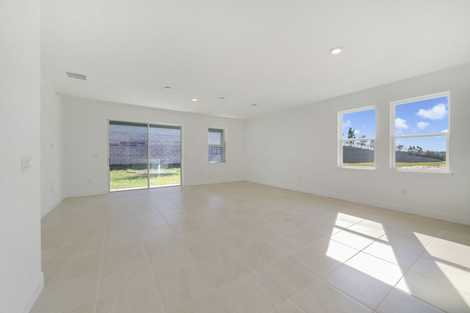 great room with view of kitchen and sliding glass door 