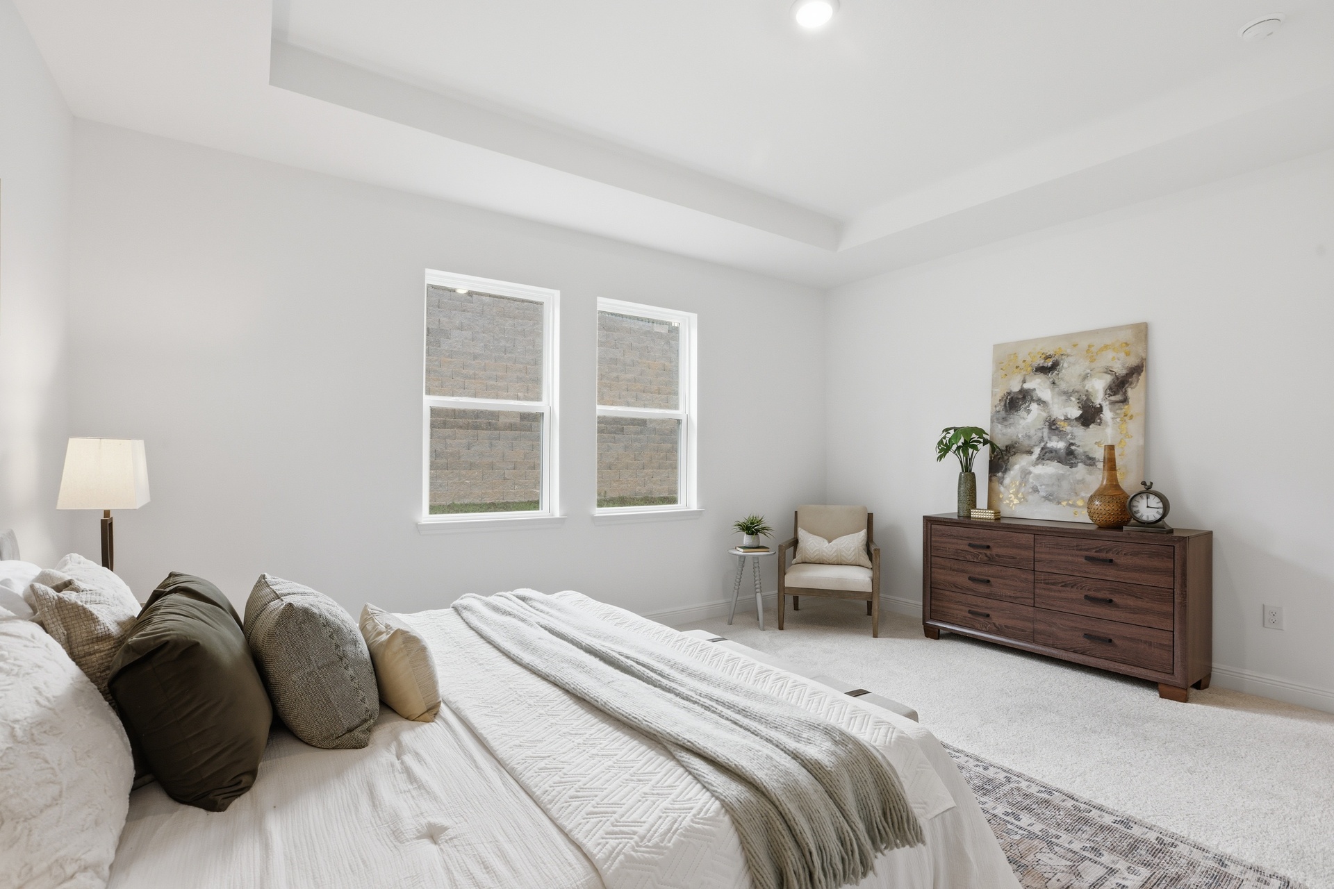 room with carpet throughout, multiple windows and tray ceilings 