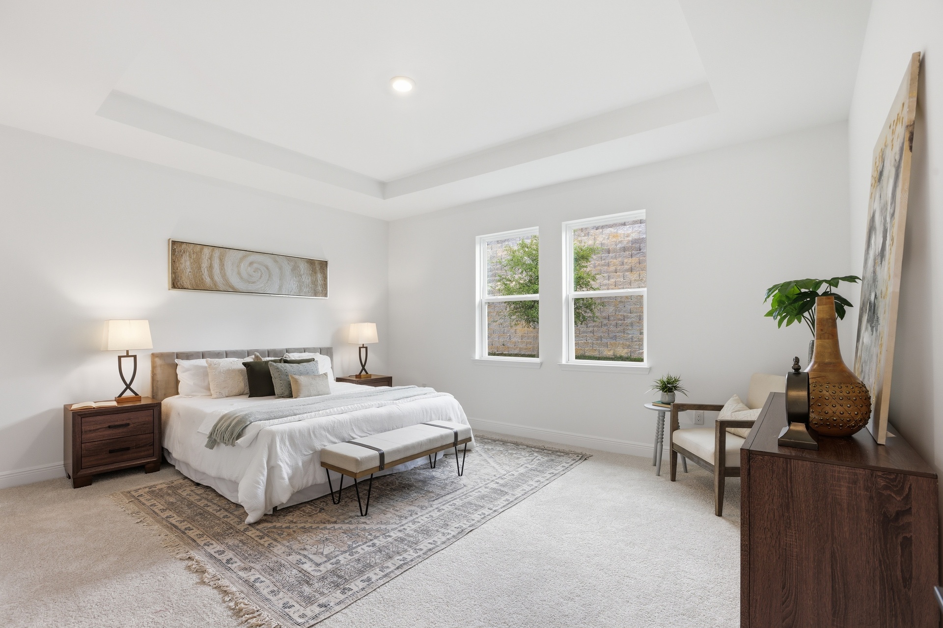 room with carpet throughout, multiple windows and tray ceilings 