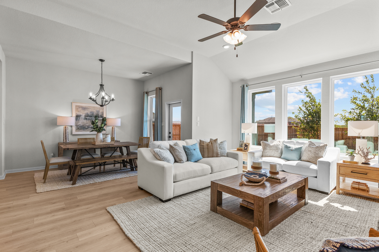 great room with white couches, a rug & dining room