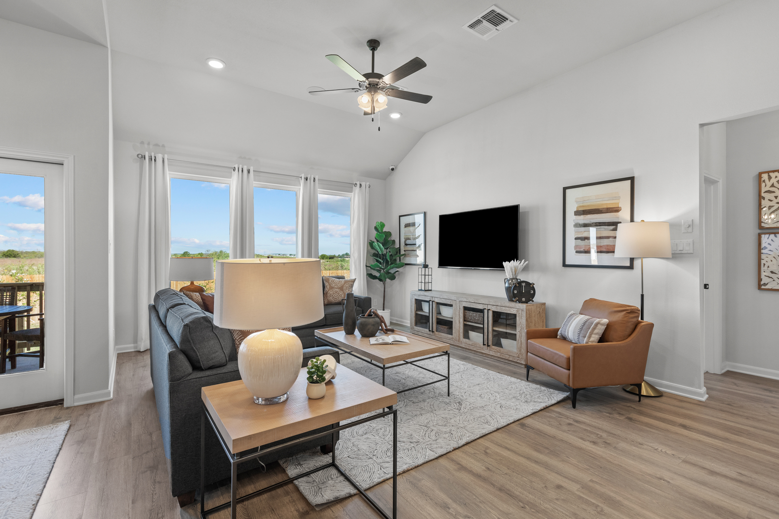 living room with gray couch, windows & rug