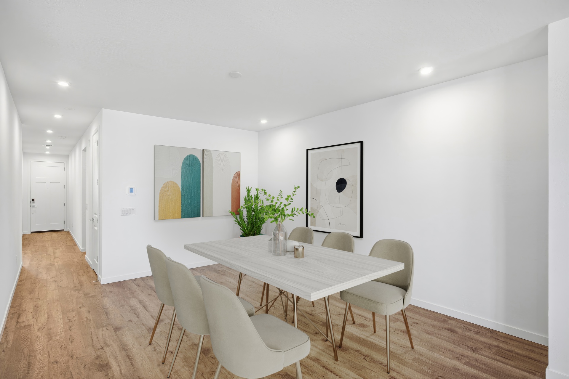 open-concept space with a white dining table, white chairs, and recessed lights