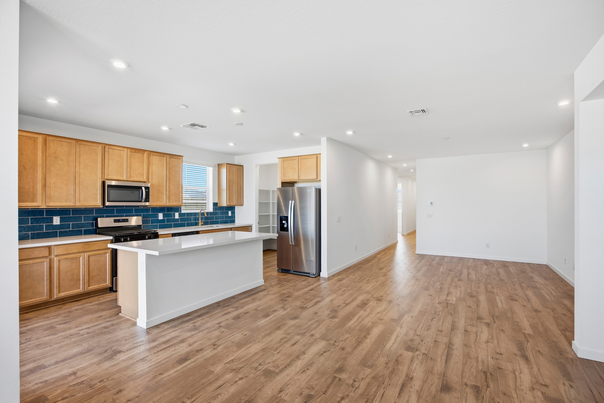 open-concept space with wood-like flooring and recessed lights